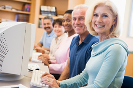 Adults sitting at a table with computers